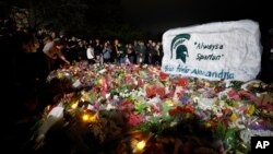 Mourners attend a vigil at The Rock on the grounds of Michigan State University in East Lansing, Mich., Feb. 15, 2023. Three students were killed in a shooting, five others remain hospitalized in critical condition. 
