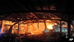 屏东县政府提供的这张图片显示了 2023 年 9 月 22 日台湾南部屏东县高尔夫球制造厂发生的工厂火灾。
