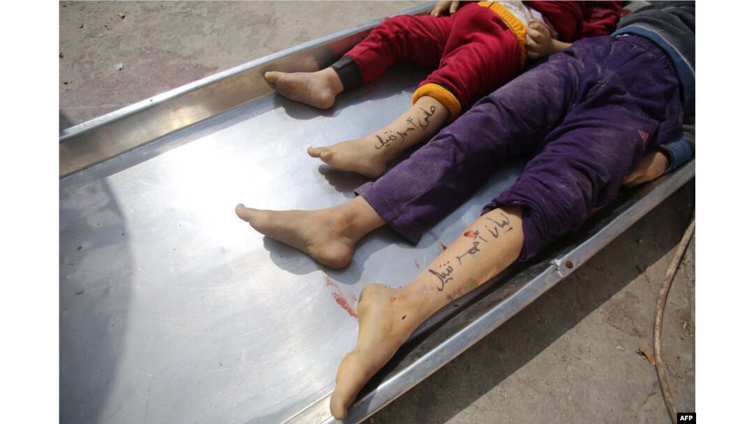 Jenazah anak-anak dari keluarga Nateel, dengan nama Hani (Kiri) dan Layan ditulis di kaki mereka oleh orang tuanya untuk membantu identifikasi, di kamar mayat rumah sakit di Deir el-Balah, 22 Oktober 2023. (Bashar TALEB / AFP)