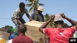 Wakaazi wa jimbo la Cabo Delgado wakishusha mizigo wakati walipokuwa wakirejea katika eneo hilo Septemba 30. 2022 .Camille LAFFONT / AFP
