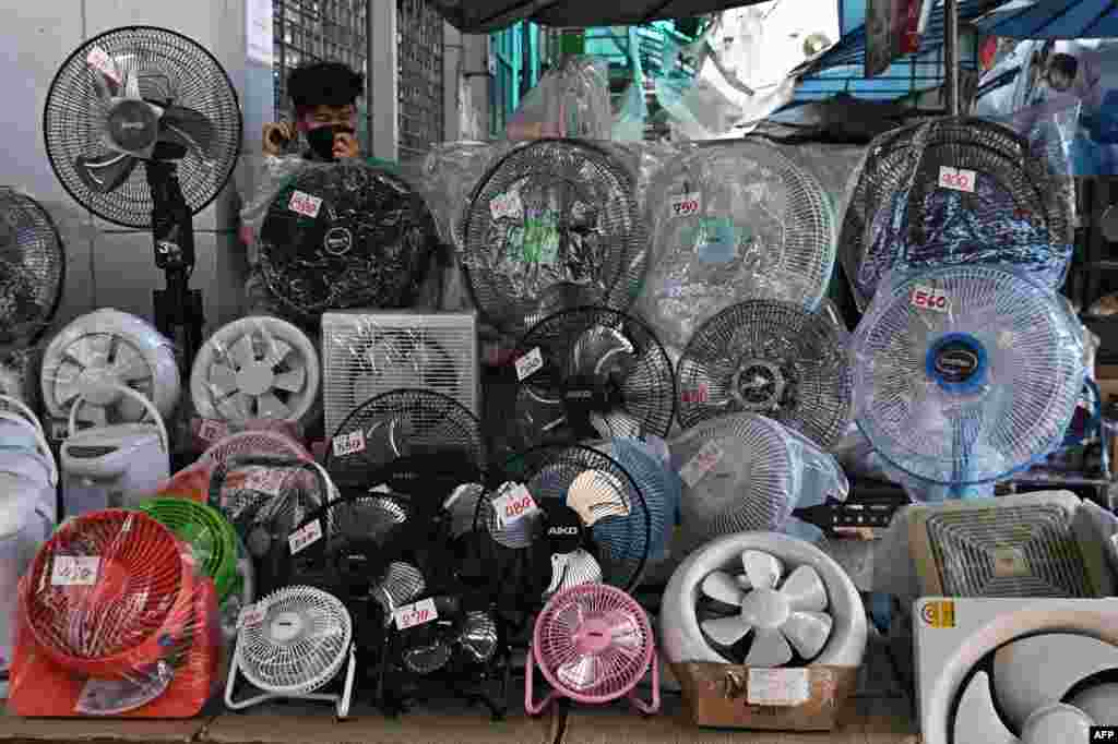 A vendor waits for customers behind a row of fans for sale to combat the heat at an electrical appliances store in Bangkok. Thailand is bracing for more hot weather with temperatures expected to rise above 40 degrees during a severe heat wave.