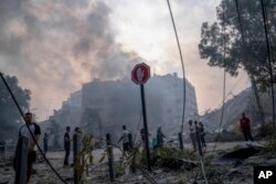 Warga Palestina memeriksa puing-puing sebuah bangunan pasca terkena serangan udara Israel, di Kota Gaza, Minggu, 8 Oktober 2023. (Foto: AP)