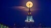 Bulan purnama, juga dikenal sebagai Bulan Bunga, terlihat di belakang Universitas Negeri Lomonosov Moskow di kota Moskow, Rusia (24/5). (Reuters)&nbsp;