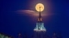 The full moon, also known as the Flower Moon, is seen behind Lomonosov Moscow State University in the city of Moscow, Russia.