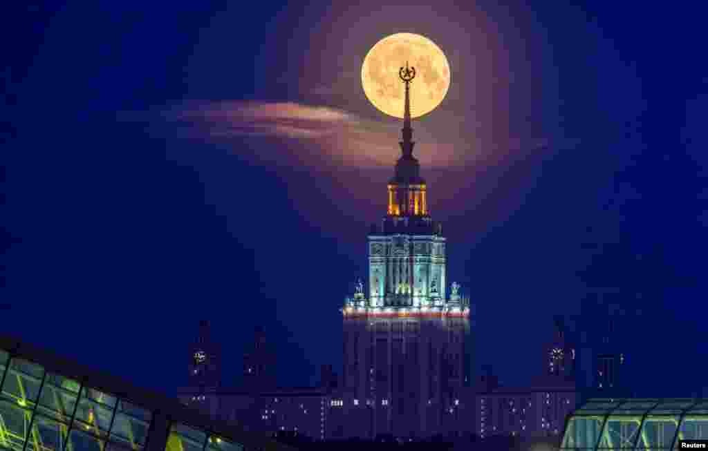 The full moon, also known as the Flower Moon, is seen behind Lomonosov Moscow State University in the city of Moscow, Russia.