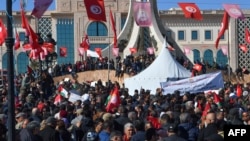Trade unionists raise national flags and placards as they take to the streets of Tunis to protest against a proposed legislation that will grant the government sweeping powers over NGOs, on March 2, 2024. 