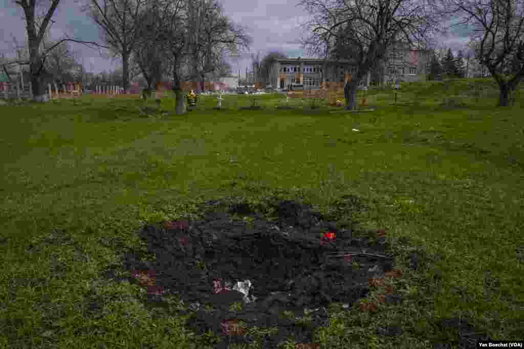 A bomb opened a little crater near the makeshift cemetery at the gardens of the local hospital in Siversk, April 4, 2023.