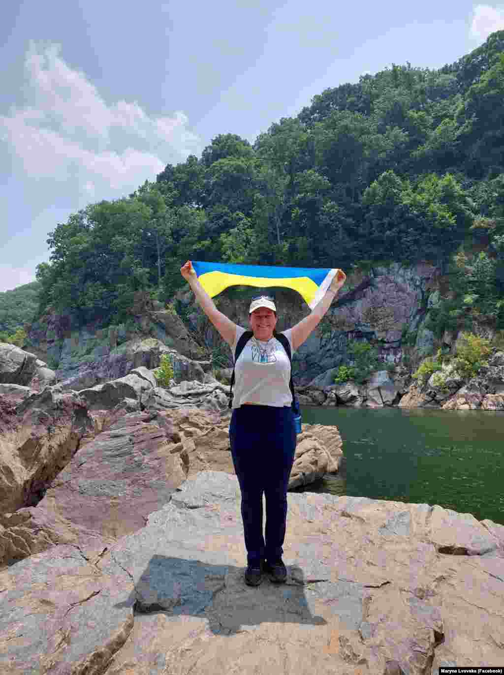 Марина Львовська тримає український прапор біля однієї з найбільших річок, що впадають в Атлантичний океан, Потомак, парк Грейт-Фолз, штат Мериленд.