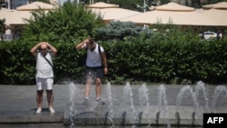 FILE - People cool off in a fountain in Belgrade, Serbia, July 8, 2024.