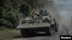 FILE - Ukrainian soldiers ride a military vehicle near the Russian border in Ukraine's Sumy region, on Aug. 10, 2024.