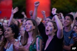 Spectators celebrate as they watch from a fan zone set up at the Club France, as Leon Marchand, of France, participates in men's 200-meter individual medley final, at the 2024 Summer Olympics, Aug. 2, 2024, in Paris, France.