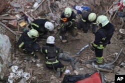 Los trabajadores de emergencia recuperan el cuerpo de un niño de 10 años que murió en un ataque aéreo ruso que afectó a un edificio de varios pisos en el centro de Kharkiv, Ucrania.