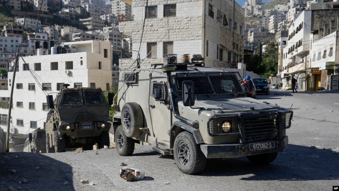 A convoy of Israeli military vehicles drives through the West Bank city of Nablus, during a raid, May 4, 2023.
