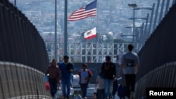 FILE - Pedestrians walk across a footbridge near the border crossing between Mexico and the United States at the San Ysidro border in San Diego, California, U.S., May 29, 2024. 