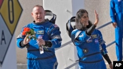 NASA astronauts Butch Wilmore, left, and Suni Williams wave as they leave the operations and checkout building for a trip to launch pad at Space Launch Complex 41 June 1, 2024, in Cape Canaveral, Fla. 