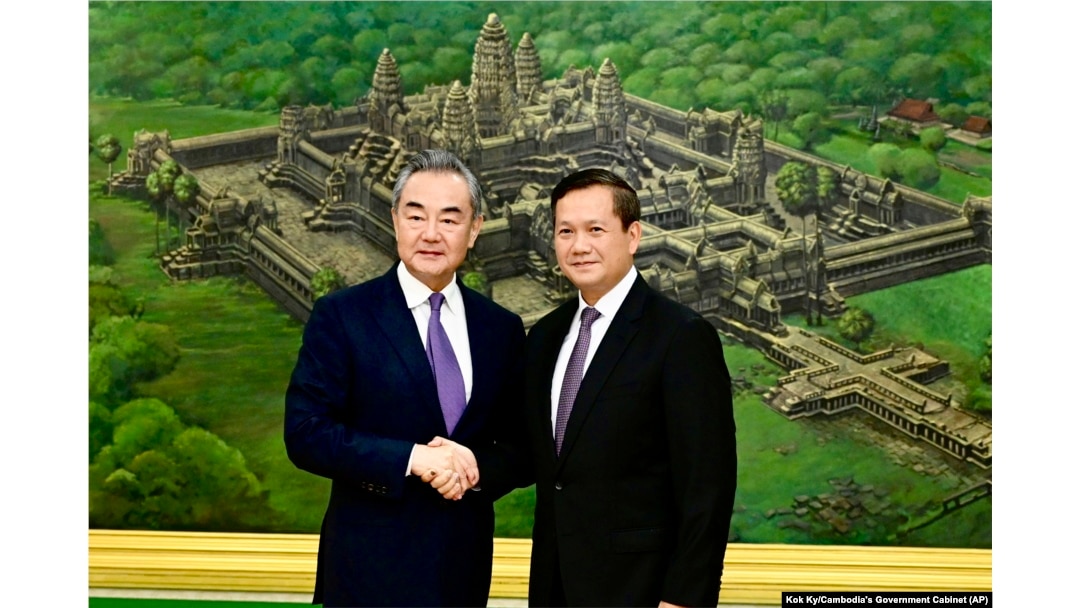 Jenderal Hun Manet (kanan) berjabat tangan dengan Menteri Luar Negeri China Wang Yi dalam pertemuan di Istana Perdamaian di Phnom Penh, Kamboja, 13 Agustus 2023. (Kok Ky/Cambodia's Government Cabinet via AP)
