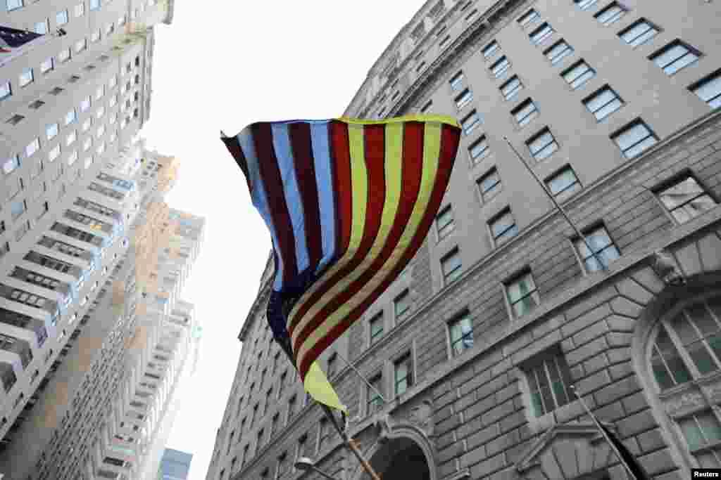 An American flag with yellow and blue coloring is seen during the Ukrainian flag-raising ceremony at Bowling Green to commemorate one year since the Russian invasion of Ukraine, in New York City, New York.