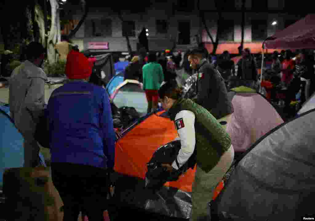 Migrantes salen de sus tiendas en el parque&nbsp;Giordano Bruno y recogen sus pertenencias.&nbsp;