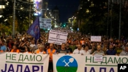 People hold banners reading, "We Won't Give up Jadar!" and march during a protest against pollution and the exploitation of a lithium mine in the country in Belgrade, Serbia, Aug. 10, 2024.