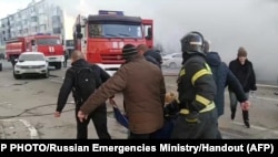 This photo taken from video released by the Russia Emergency Situations Ministry on Dec. 30, 2023, shows people evacuating an injured person after shelling in Belgorod, Russia, about 30 kilometers (19 miles) from the border with Ukraine.