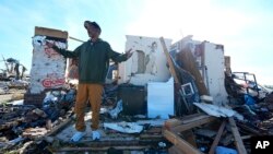 Jermaine Wells, vecino de Lonnie y Melissa Pierce, quienes murieron cuando el camión cayó encima de su casa durante un tornado que azotó tres días antes, muestra las ruinas de su propia casa, el lunes 27 de marzo de 2023, en Rolling Fork, Mississippi. (Foto AP/Julio Cortés)