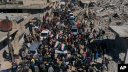 People attend the funeral of four Kurds killed in the town of Jinderis, Syria, March 21, 2023.