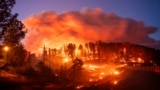 Seen in a long exposure photograph, the Park Fire burns along Highway 32 in the Forest Ranch community of Butte County, Calif., on July 25, 2024. 