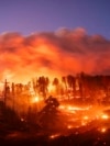 Seen in a long exposure photograph, the Park Fire burns along Highway 32 in the Forest Ranch community of Butte County, Calif., on July 25, 2024. 