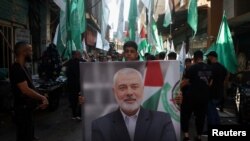 Seorang warga Palestina tampak membawa foto pemimpin Hamas Ismail Haniyeh, yang tewas terbunuh di Iran, dalam aksi mengutuk pembunuhan terhadap Haniyeh di kamp pengungsi Palestina Burj al-Barajneh di Beirut, Lebanon, pada 31 Juli 2024. (Foto: Reuters/Mohamed Azakir)