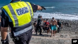 FILE: Migrants, most of them from Morocco, are escorted by Spanish Police after arriving at the coast of the Canary Islands, Spain on Monday, Nov. 23, 2020, after crossing the Atlantic Ocean sailing on a wooden boat.