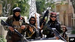 Pasukan Taliban mengibarkan bendera mereka saat berpatroli di Kabul, Afghanistan, 19 Agustus 2021.(Foto: AP)