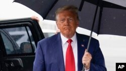 FILE - Former President Donald Trump walks over to speak with reporters before he boards his plane at Ronald Reagan Washington National Airport, Aug. 3, 2023, in Arlington, Virginia, after facing a judge on federal conspiracy charges.