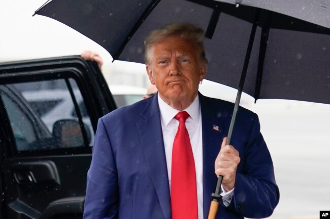 Former President Donald Trump walks over to speak with reporters before he boards his plane at Ronald Reagan Washington National Airport, Aug. 3, 2023, in Arlington, Va., after facing a judge on federal conspiracy charges.