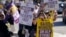 Martha Canul, foreground, a medical assistant at Kaiser, holds up signs along with medical workers and supporters as they protest outside of a Kaiser Permanente facility in San Francisco, Oct. 4, 2023.