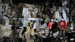 Ukrainian State Emergency Service firefighters inspect a damaged house after Russian shelling hit in Zaporizhzhia, Ukraine, March 2, 2023.