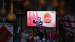 A TV screen at a convenience store shows live coverage as Chinese President Xi Jinping swears an oath after being reelected as president for a third term during the third plenary session of the National People's Congress in Beijing, March 10, 2023.