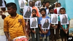 FILE- Ahead of Kamala Harris' inauguration as U.S. vice president, children hold portraits of her at a Hindu temple in Thulasendrapuram, the hometown of Harris' maternal grandfather, south of Chennai, Tamil Nadu state, India, Jan. 20, 2021.