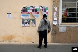 A man looks at electoral posters of candidates for the March 1 parliamentary election, in downtown Tehran, Iran, Feb. 22, 2024.