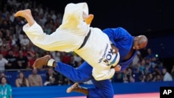 South Korea's Min-Jong Kim and France's Teddy Riner compete during their men's +100 kg final match in the team judo competition, at Champ-de-Mars Arena, during the 2024 Summer Olympics, in Paris, France, Aug. 2, 2024.