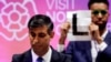 Independent candidate Niko Omilana holds an "L" sign behind British Prime Minister Rishi Sunak as he speaks after winning his seat at Richmond and Northallerton during the UK election in Northallerton, Britain.