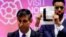 Independent candidate Niko Omilana holds an "L" sign behind British Prime Minister Rishi Sunak as he speaks after winning his seat at Richmond and Northallerton during the UK election in Northallerton, Britain.