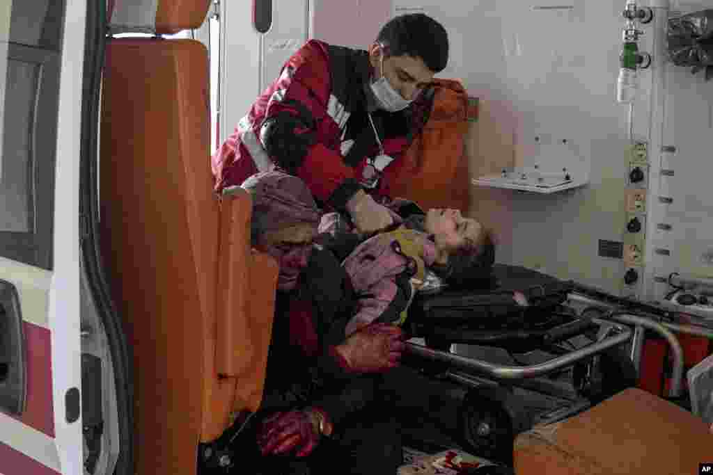 Сотрудник скорой помощи пытается спасти девочку, пострадавшую при обстреле жилого района Мариуполя. Рядом сидит ее отец. Девочка не выжила. 27 февраля 2022.