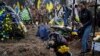 Natalia cries at the grave of her husband and Ukrainian serviceman Andrii Neshodovskiy during his funeral in Kyiv, Ukraine, March 25, 2023. 