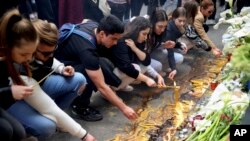 School children light candles near the Vladislav Ribnikar school in Belgrade, Serbia, Thursday, May 4, 2023.