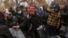 Migrants pick up blankets near a migrant assistance center at St. Brigid Elementary School on Dec. 5, 2023, in New York. 