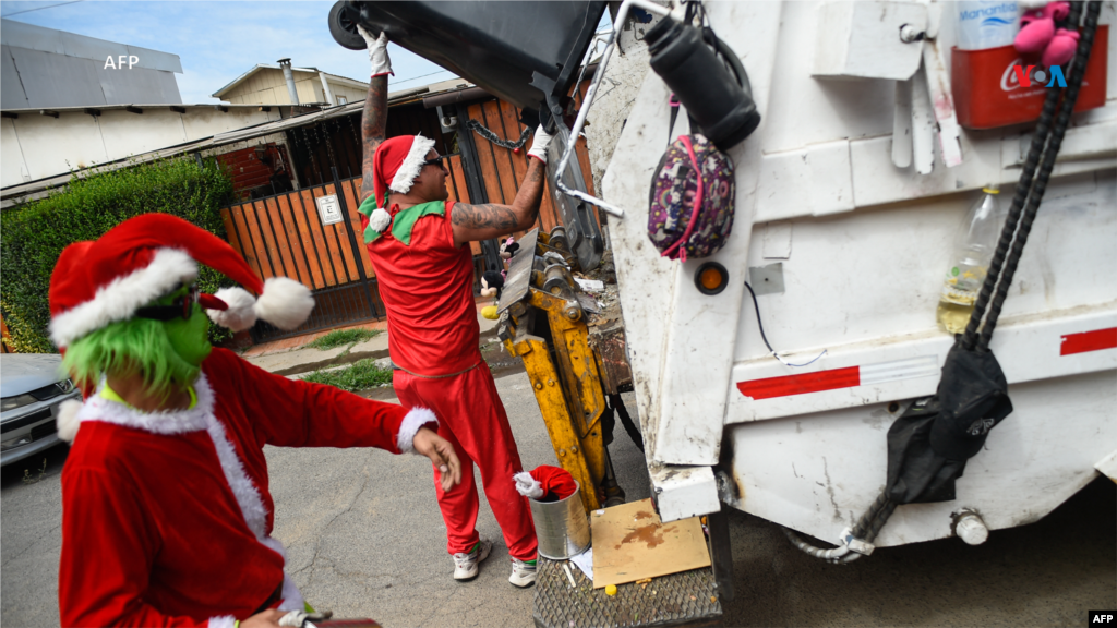 Desde Chile: Recolectores de basura del municipio de Puente Alto vestidos como personajes navideños recogen propinas mientras recogen la basura en la víspera de Navidad, en Santiago el 23 de diciembre de 2023.