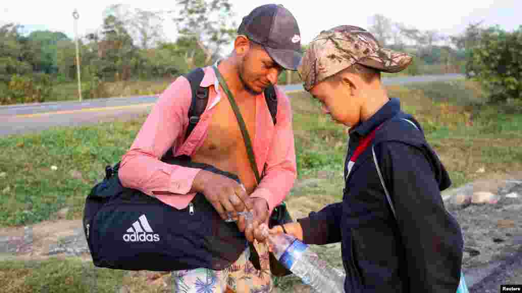 Migrantes comparten agua mientras continúan su viaje. 