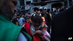 Los palestinos rescatan a una niña de los escombros de un edificio residencial destruido en la Franja de Gaza el 10 de octubre de 2023.