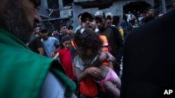 Palestinians rescue a girl from the rubble of a destroyed residential building in the Gaza Strip on Oct. 10, 2023.