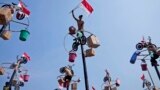A participant celebrates after reaching the prizes during a greased-pole climbing competition held as a part of the Independence Day celebrations at Ancol Beach in Jakarta, Indonesia, Aug. 17, 2023. 
